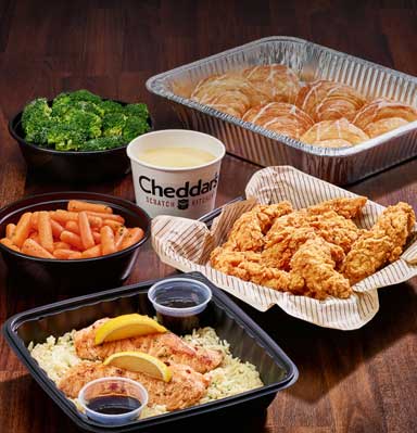 Get a family bundle at Cheddar's. Get sides of broccoli, carrots, croissants, and queso with your choice of grilled salmon or chicken tenders. 